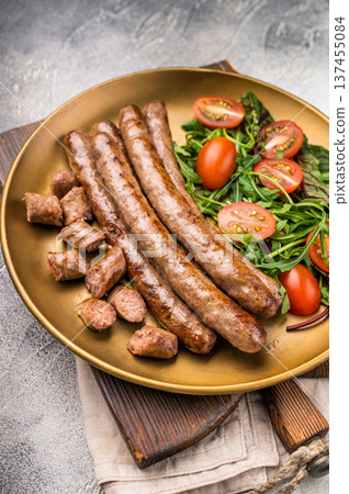 Close up of perfectly charred grilled sausage with salad, ideal for adding flavor to your favorite dishes or sandwiches. white background. top view Close up of perfectly charred grilled sausage with salad, ideal for adding flavor to your favorite dishes or sandwiches. white background. top view 137455084