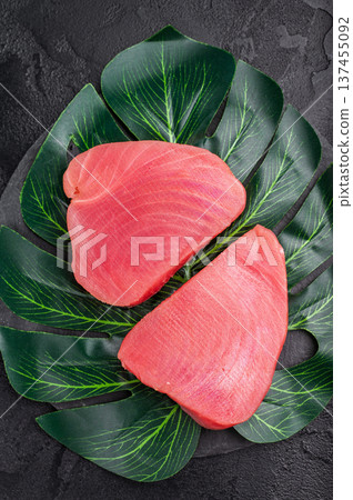 Beautifully cut raw tuna steak, rich in flavor and omega 3s, ready to elevate your culinary creations. black background. top view Beautifully cut raw tuna steak, rich in flavor and omega 3s, ready to elevate your culinary creations. black background. top view 137455092
