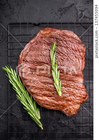 A mouthwatering grilled top sirloin or rump beef steak, showcasing beautiful grill marks. black background. top view 137455094
