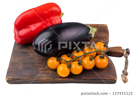 Fresh vegetables on wooden cutting board isolated on white background, red bell pepper eggplant and yellow cherry tomatoes 137455125