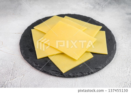 Square slices of mild creamy cheese with rosemary and thyme on slate board, Gouda Edam type dairy for sandwiches and cooking Square slices of mild creamy cheese with rosemary and thyme on slate board, Gouda Edam type dairy for sandwiches and cooking 137455130