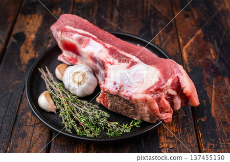 Raw bone-in beef cut with herbs and garlic, traditional ingredient for slow cooking, braising and deep flavored comfort meals. Raw bone-in beef cut with herbs and garlic, traditional ingredient for slow cooking, braising and deep flavored comfort meals. 137455150