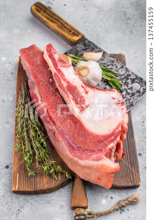 Raw beef soup bone with marrow and meat on rustic board with garlic and herbs, perfect ingredient for rich homemade broth and stock. 137455159