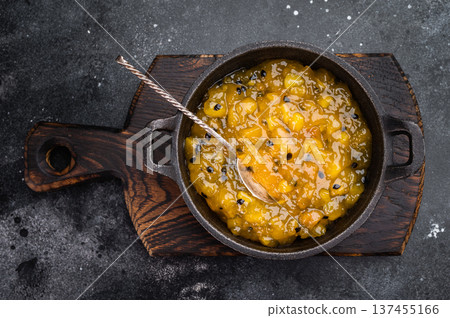 Granadilla mango fruit coulis in cast iron pan, vibrant tropical dessert topping with rich color and shine Granadilla mango fruit coulis in cast iron pan, vibrant tropical dessert topping with rich color and shine 137455166