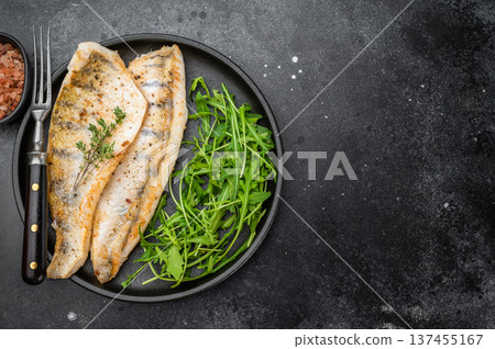 Pan fried pike perch fillet served with fresh arugula in plate, healthy freshwater fish meal. Pan fried pike perch fillet served with fresh arugula in plate, healthy freshwater fish meal. 137455167
