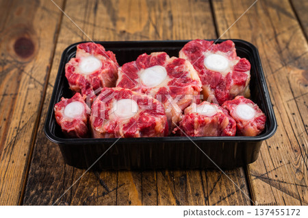 Raw beef Oxtail pieces with bone marrow in tray, top view rustic food preparation scene with copy space 137455172
