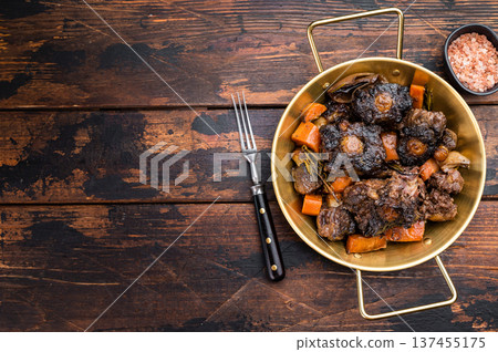 Slow cooked oxtails with vegetables and herbs, hearty comfort food served in rustic pan, top view with copy space Slow cooked oxtails with vegetables and herbs, hearty comfort food served in rustic pan, top view with copy space 137455175