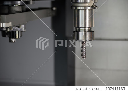 Close-up of a flat nose end mill secured in a high-precision tool holder attached to a CNC machine spindle. 137455185