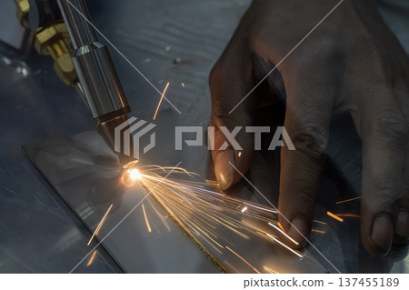 Precision laser welding demonstration performed by a skilled operator for high-quality industrial metal fabrication. Precision laser welding demonstration performed by a skilled operator for high-quality industrial metal fabrication. 137455189