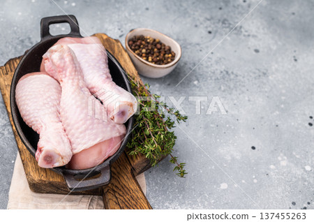 Fresh chicken drumsticks, raw poultry showcasing their rich color and tender texture, ready for marinating and grilling. grey background. top view 137455263