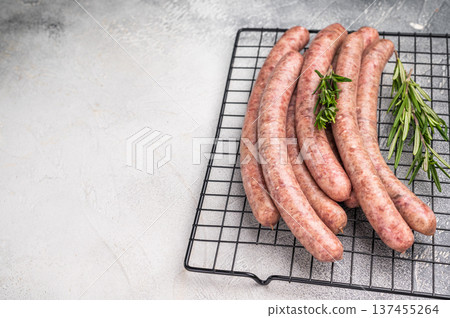 Fresh raw sausage links ready for grilling, perfect for barbecues or hearty family meals..white background. top view Fresh raw sausage links ready for grilling, perfect for barbecues or hearty family meals..white background. top view 137455264