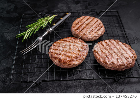 Juicy grilled meat patty cutlet with perfect grill marks, ideal for mouthwatering burgers and summer barbecues. black background. top view 137455270