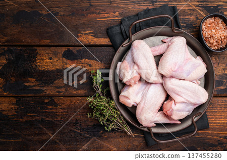 Pristine raw poultry wings, waiting to be seasoned and transformed into mouthwatering dishes for any occasion. wooden background. top view 137455280