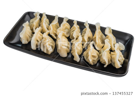 Soft pleated Asian dumplings with savory filling served on dark plate overhead shot great for stock images and menu design. 137455327