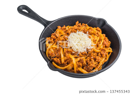 Delicious pasta bolognese with savory meat ragu and parmesan shreds presented in a cast iron skillet on minimalist white background. Delicious pasta bolognese with savory meat ragu and parmesan shreds presented in a cast iron skillet on minimalist white background. 137455343