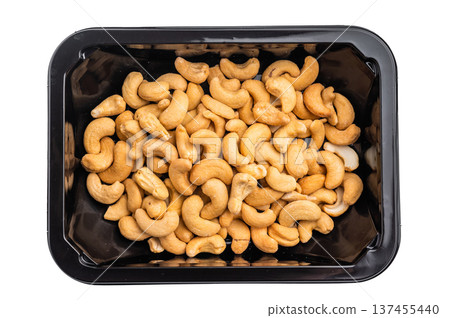 Cashew nuts packed in a black plastic container on a bright white background creating a clean ingredient 137455440