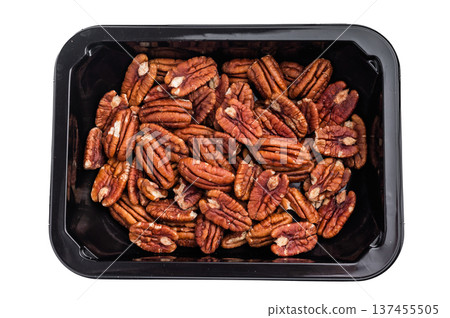 Raw pecan halves packed in a black plastic container on a clean white background creating a simple ingredient image ideal for culinary stock themes 137455505