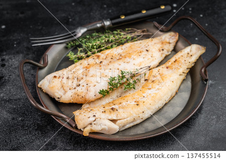 Roasted flaky whitefish fillets with fresh thyme, overhead food photo on moody dark background with copy space. 137455514