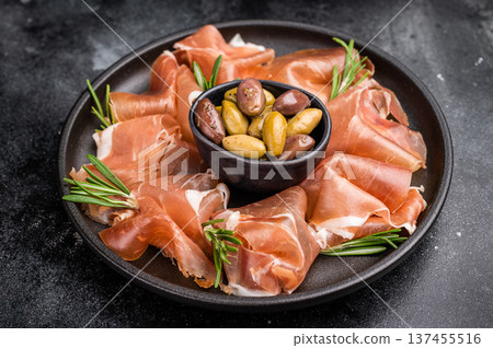 Classic Charcuterie Board with Prosciutto and olives. Dark and rustic food photography for high-end menus or blogs. Classic Charcuterie Board with Prosciutto and olives. Dark and rustic food photography for high-end menus or blogs. 137455516
