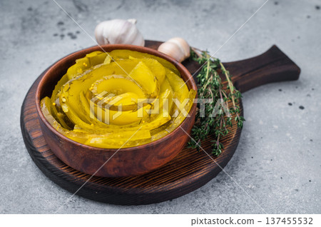 Crisp brined cucumber spirals with dill and mustard seeds served in a wooden bowl on textured gray background in flatlay style. Crisp brined cucumber spirals with dill and mustard seeds served in a wooden bowl on textured gray background in flatlay style. 137455532