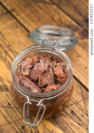 Rustic venison preserved stew in a glass jar with garlic, thyme and pepper on a wooden board. Hearty wildgame meat with rich slowcooked flavor. Rustic venison preserved stew in a glass jar with garlic, thyme and pepper on a wooden board. Hearty wildgame meat with rich slowcooked flavor. 137455537