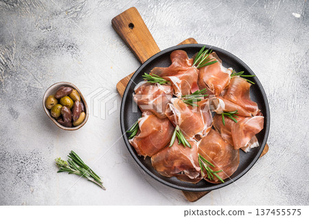 Rustic Charcuterie Board with Jambon Crudo and herbs on a textured stone surface. Rustic Charcuterie Board with Jambon Crudo and herbs on a textured stone surface. 137455575