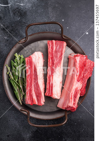 Premium raw beef short ribs for barbecue or braising. Fresh meat close-up, horizontal orientation on a rustic serving tray. Premium raw beef short ribs for barbecue or braising. Fresh meat close-up, horizontal orientation on a rustic serving tray. 137455697