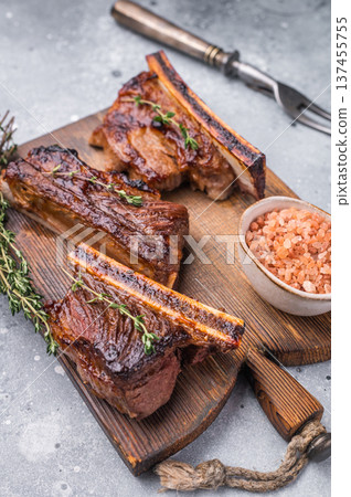 Premium grilled short ribs with thyme and pink salt. Ample gray copy space for text or design. Premium grilled short ribs with thyme and pink salt. Ample gray copy space for text or design. 137455755