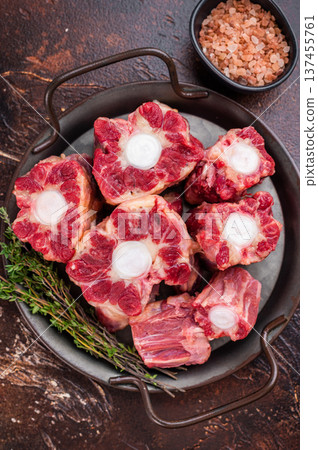 Raw Oxtail pieces in pan with fresh thyme, top view rustic food scene showing collagen rich beef for stock 137455761