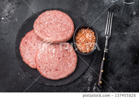 Fresh raw beef meat patty ready for grilling, perfect for homemade burgers and delicious family meals.black background. top view 137455828