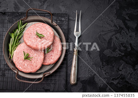 Freshly formed raw meat patty with herbs for burgers, perfect for grilling or frying to satisfy your cravings. black background. top view 137455835
