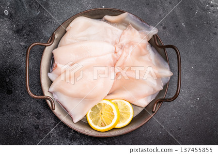 Fresh raw squid ready for preparation, perfect for sushi, stir-fries, or gourmet seafood dishes. black background. top view Fresh raw squid ready for preparation, perfect for sushi, stir-fries, or gourmet seafood dishes. black background. top view 137455855