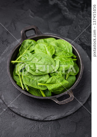 Crisp and lush fresh spinach ready for your favorite recipes, a versatile superfood for every meal. black background. top view Crisp and lush fresh spinach ready for your favorite recipes, a versatile superfood for every meal. black background. top view 137455856