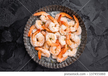 A plate of shrimp. The shrimp are arranged in a circular pattern, with some of them overlapping each other. The dish looks appetizing and inviting. 137455860