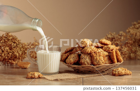 Oatmeal cookies and milk sit on a kitchen table. Oatmeal cookies and milk sit on a kitchen table. 137456031