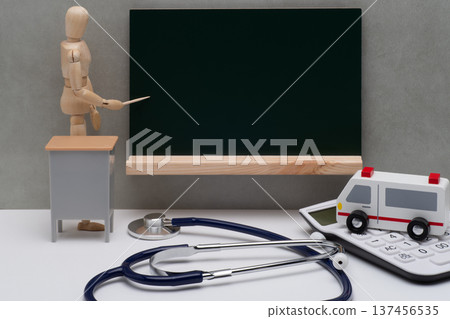 A drawing doll showing a blackboard, an ambulance and a stethoscope 137456535