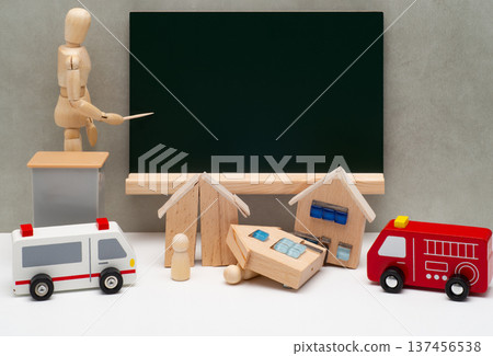 一個人物畫著一個黑板，旁邊是一棟被地震摧毀的房子和一輛救護車。 137456538