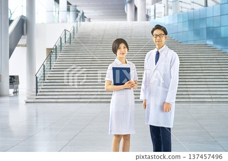 Doctor and nurse looking at you. Trust, smile, hospital, guidance, medical care, whole body, copy space, relief, sincerity 137457496