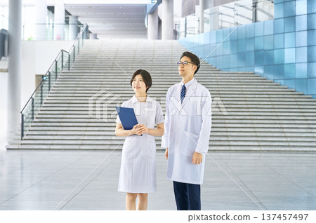 醫生和護士站在醫院大廳。全身照。留白。醫療保健的未來。廣告素材。誠實。信任。 醫生和護士站在醫院大廳。全身照。留白。醫療保健的未來。廣告素材。誠實。信任。 137457497