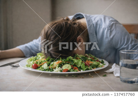 The man fell asleep on his face in a plate of salad. 137457760