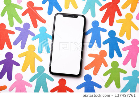 A smartphone among multi-colored paper figures of people. A smartphone among multi-colored paper figures of people. 137457761