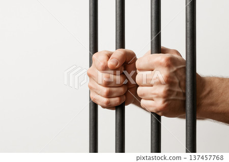 Hands behind prison bars as a symbol of unfreedom. Space for text. Hands behind prison bars as a symbol of unfreedom. Space for text. 137457768
