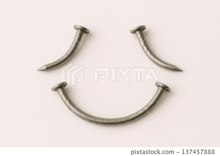 Nails bent in the shape of a smiling face. Nails bent in the shape of a smiling face. 137457888