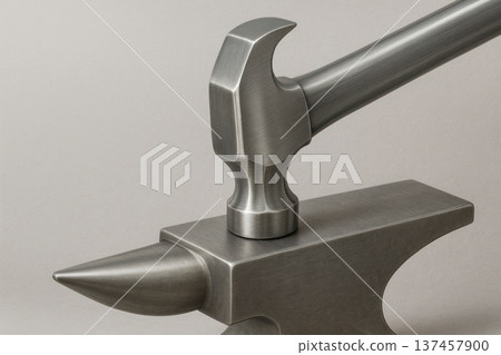 A metal hammer connected to an anvil in a monolithic form. Space for text. 137457900