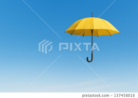 A yellow umbrella hovering in a clear blue sky. Space for text. 137458018