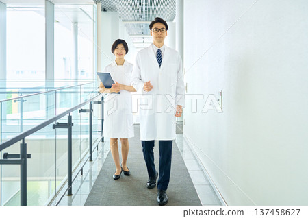 Smiling doctors and nurses walking in the hospital corridor Medical team Trust Whole body 137458627