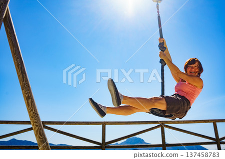 Adult woman having fun on zipline 137458783