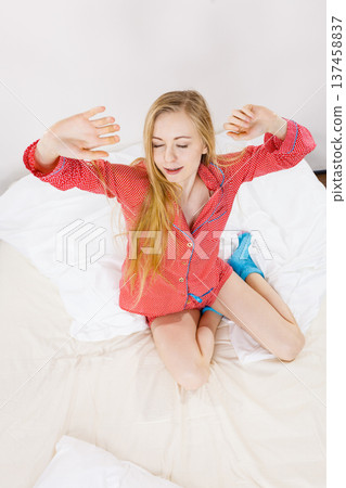 Awaken woman stretching body after sleeping 137458837