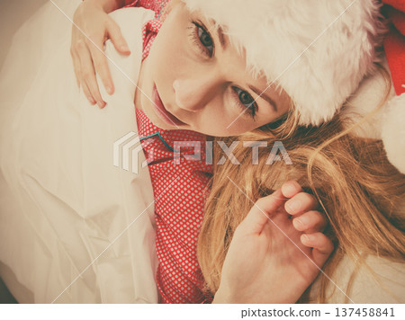 Happy woman wearing pajamas and Santa Claus hat Happy woman wearing pajamas and Santa Claus hat 137458841