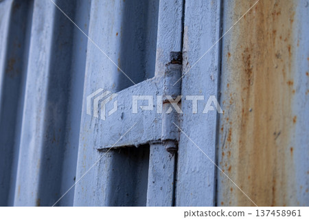 A metal gate is shown from a close angle, highlighting the texture and rust on the surface in a residential area during late afternoon light A metal gate is shown from a close angle, highlighting the texture and rust on the surface in a residential area during late afternoon light 137458961